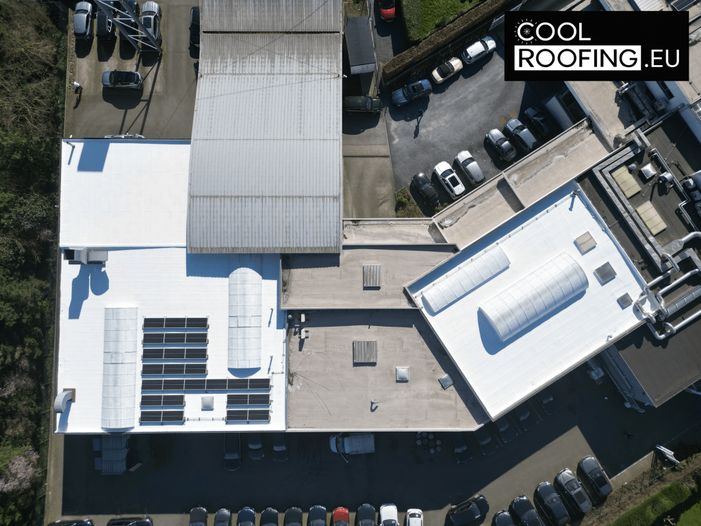 Toiture industrielle peinte en blanc avec panneaux solaires sur un garage BMW à Liège