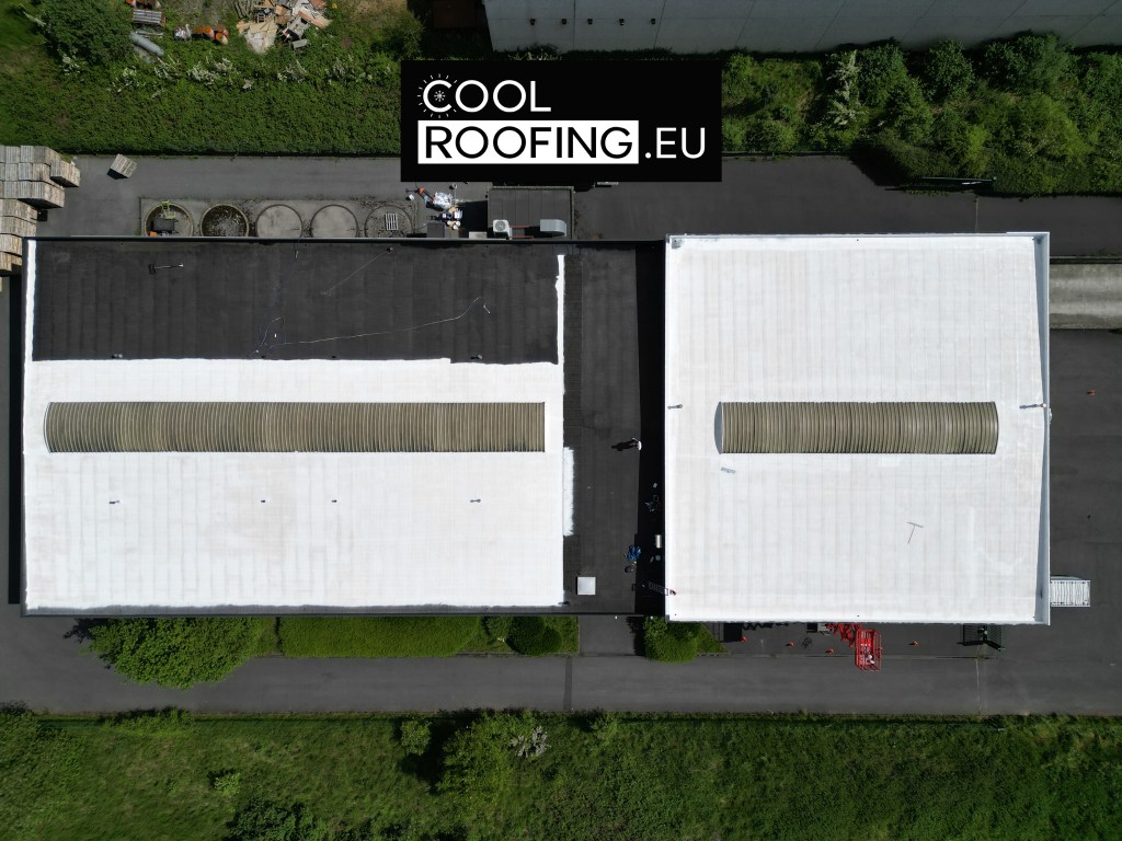 Un hangar industriel dont le toit est en cours de peinture blanche, avec des ouvriers appliquant un revêtement réfléchissant sur la surface.